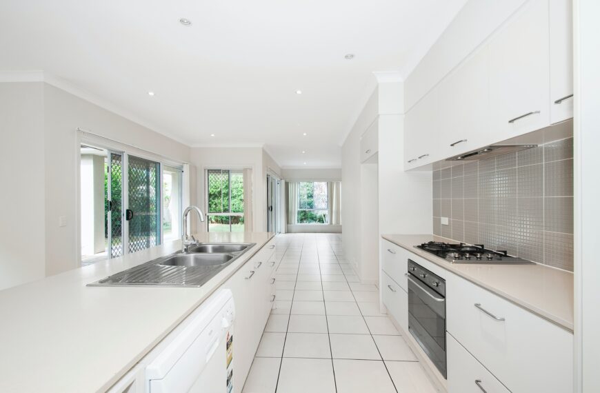 white kitchen, silver cooktop, white counters, tile floor, dishwasher